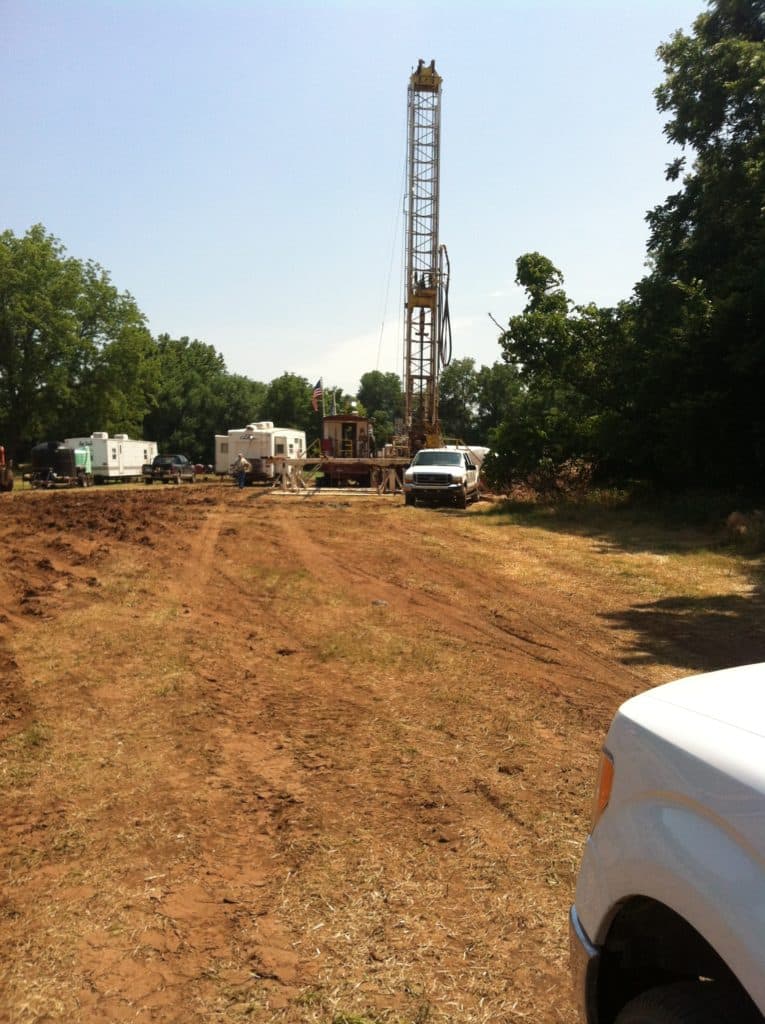 Drilling rig and support vehicles on a cleared lease location