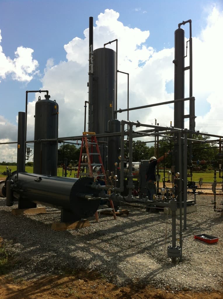 Oil and gas production equipment with tanks, piping, and well controls